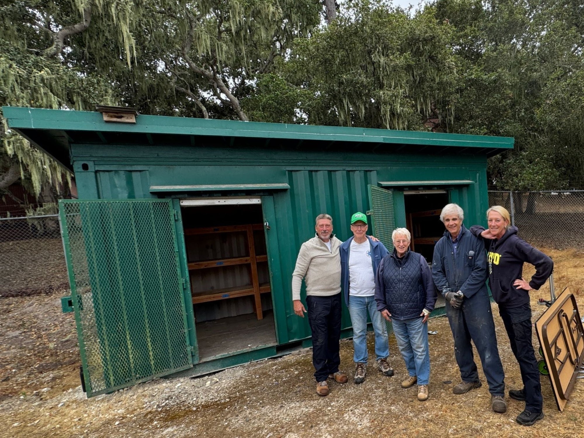 CERT volunteers stand in front of an emergency supply container after relocating it to a safer, accessible site at Monterey Peninsula College, supporting community disaster preparedness.